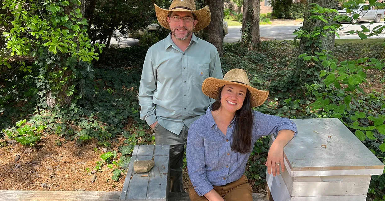 Matt and Krysta next to a honeybee hive