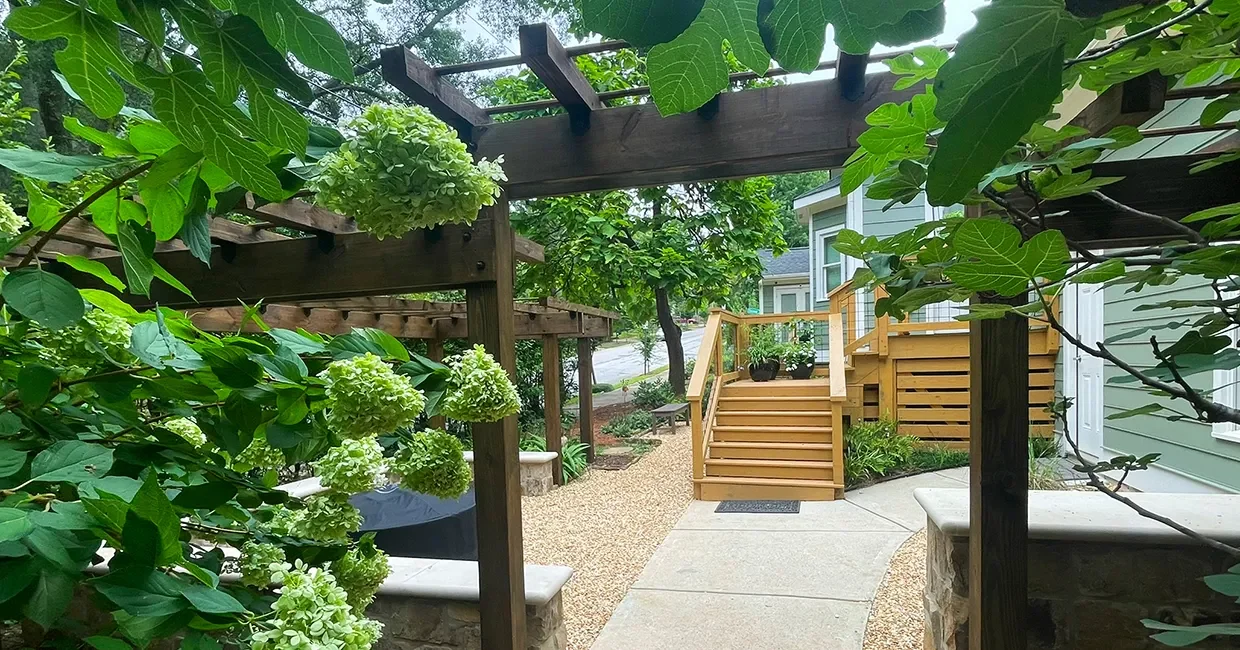 View of perennial shade garden through fire pit area and pergola